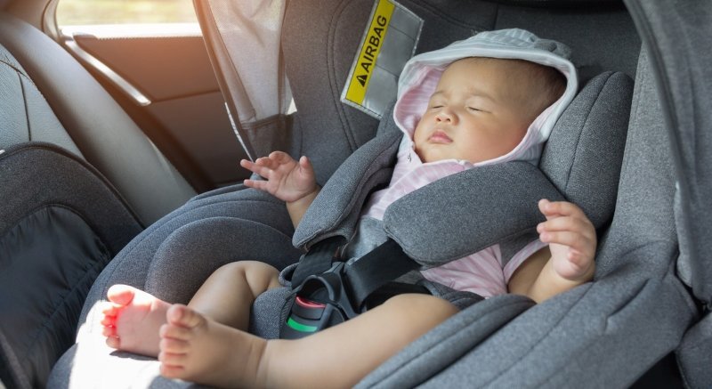 Nou-născutul doarme în scaunul auto