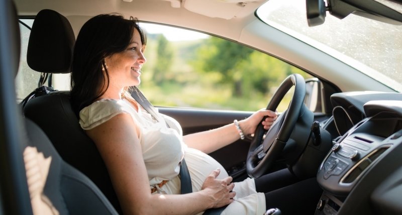 Pregnant woman sitting in car