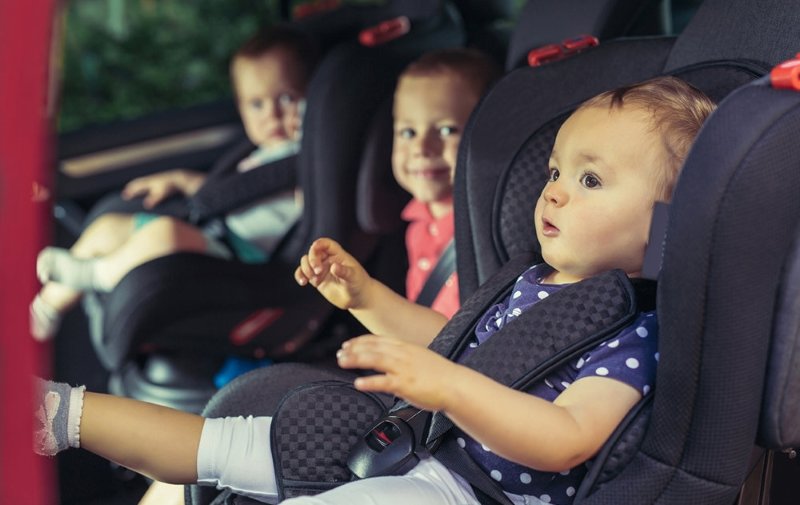 Three children in car safety seat